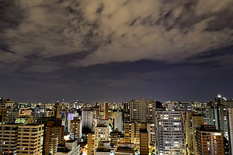 Night Cityscape with Cloudy Sky and Urban Lights