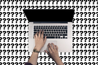 Hands typing on laptop with question mark background pattern