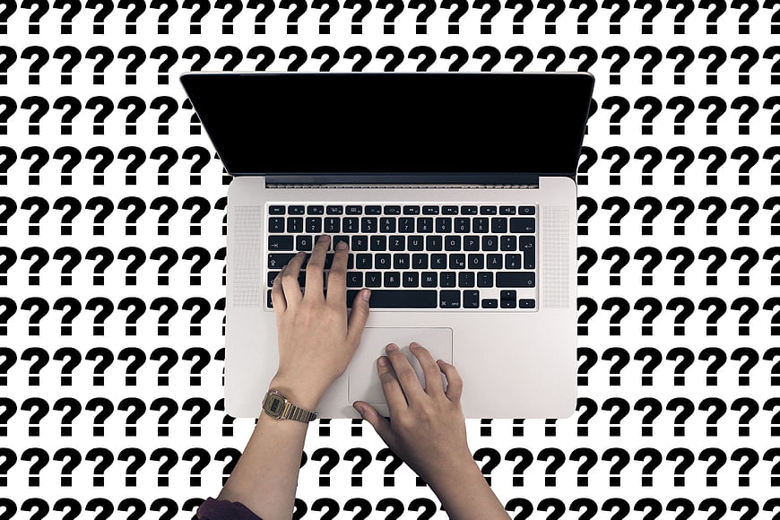 Hands typing on laptop with question mark background pattern