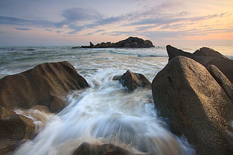 Long Exposure Ocean Waves Crashing on Granite Rocks at Sunset
