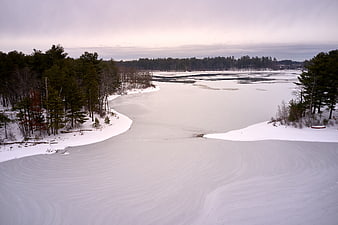 Aerial view of frozen lake with wind-swept snow patterns