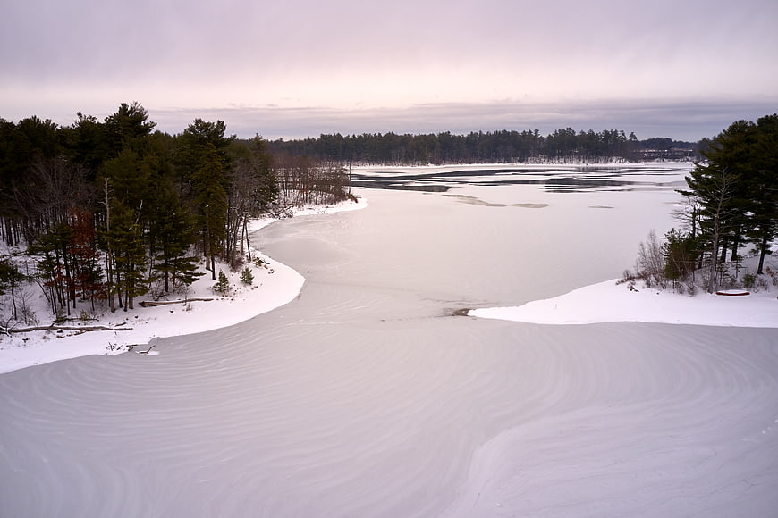 Aerial view of frozen lake with wind-swept snow patterns