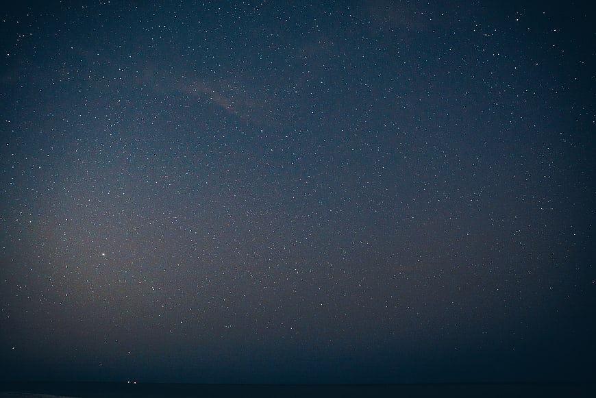 Starry Night Sky Over Dark Ocean Horizon