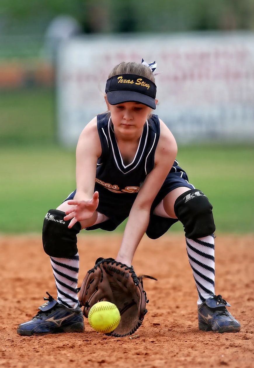 Young Female Softball Player Fielding a Ground Ball