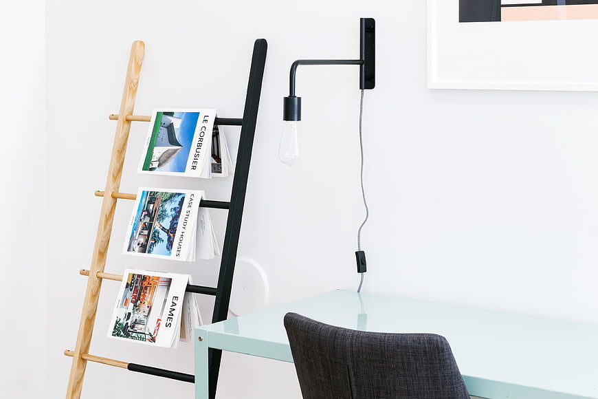 Modern minimalist office corner with magazine rack and desk
