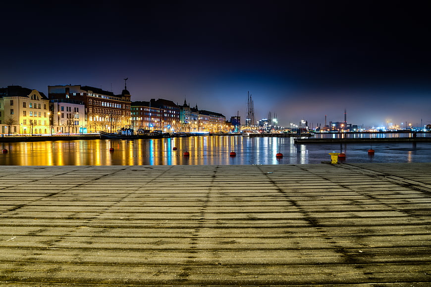 Night View of Helsinki Harbor with Wooden Pier and City Lights
