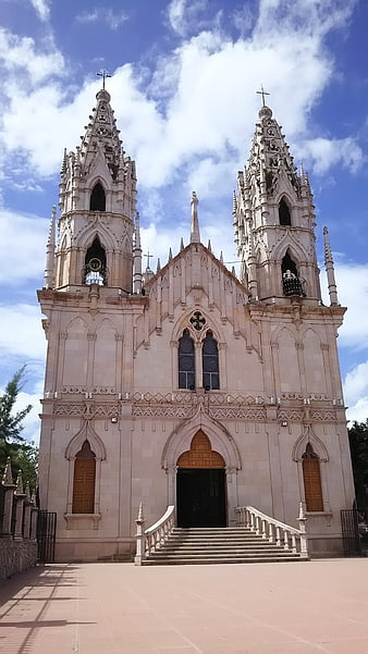 Gothic Revival Church with Twin Spires Under Blue Sky