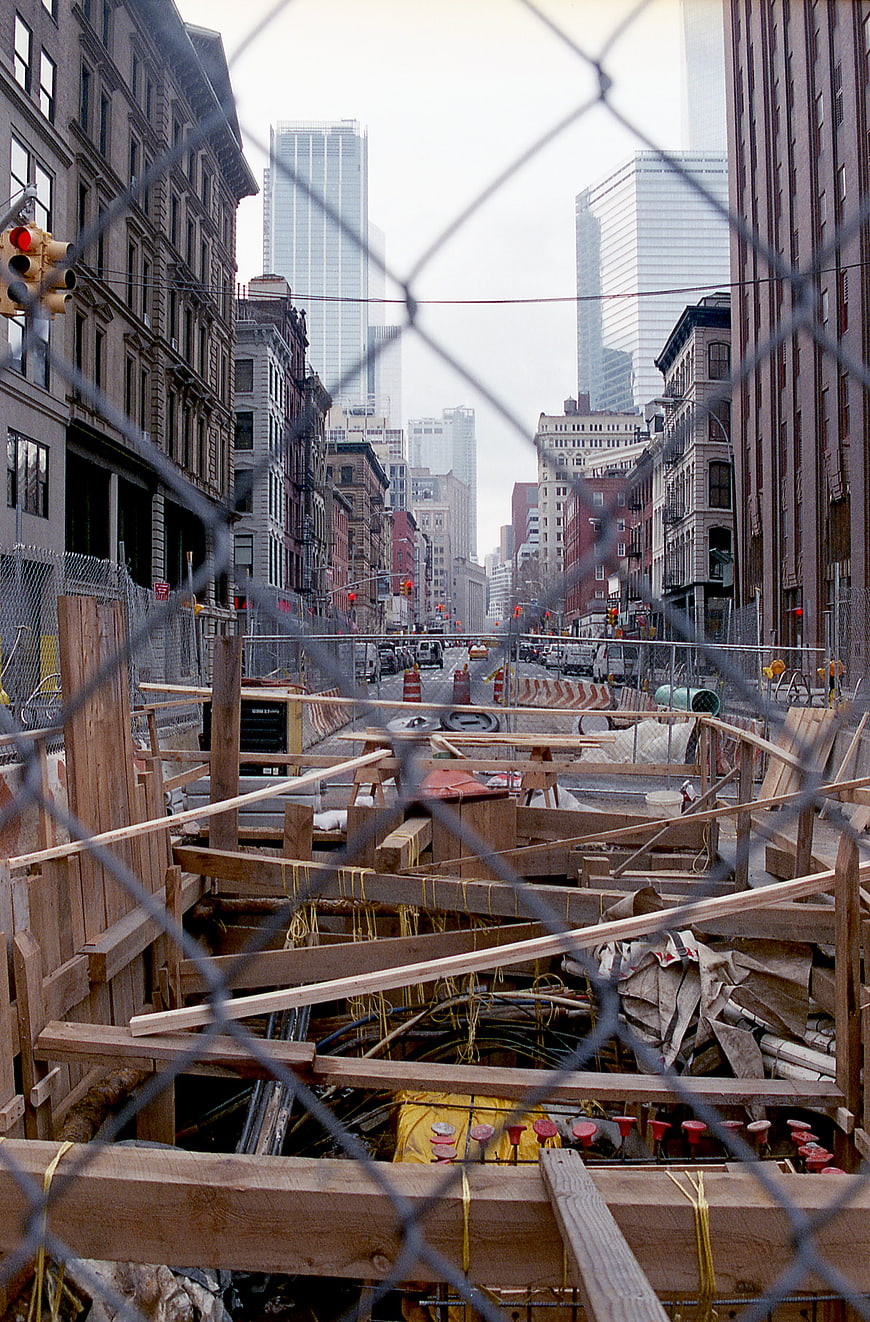 Urban construction site viewed through chain-link fence