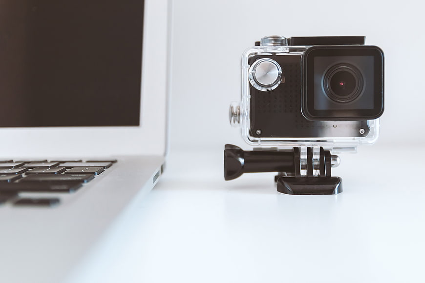 Action Camera on Desk Next to Laptop