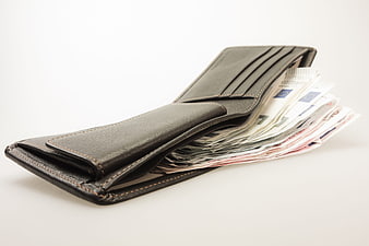 Black leather wallet filled with euro banknotes on white background
