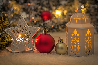 Festive Christmas decorations with glowing lanterns and ornaments on snow