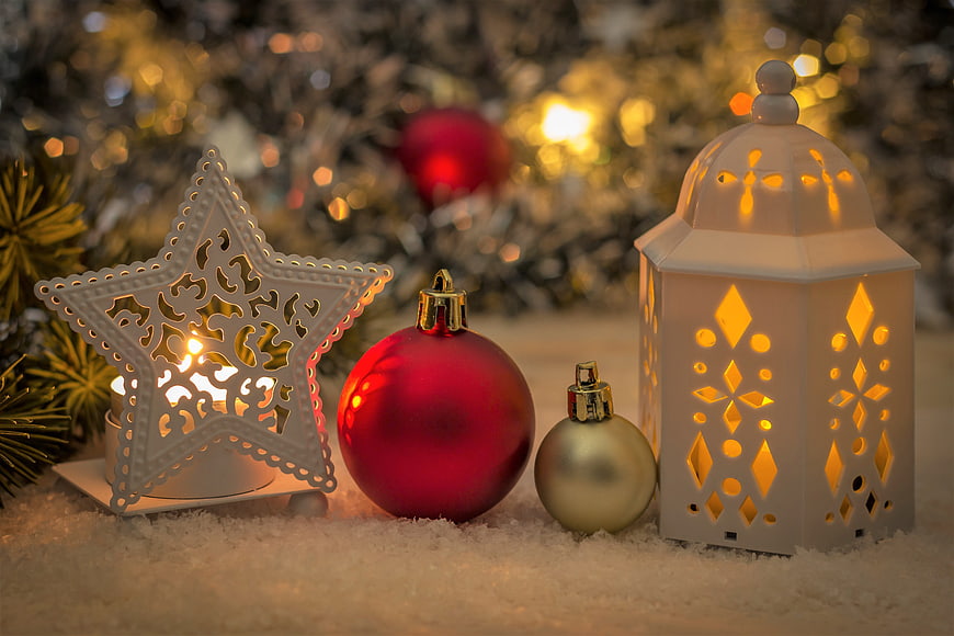 Festive Christmas decorations with glowing lanterns and ornaments on snow