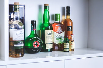 Collection of whiskey and liquor bottles on white shelf