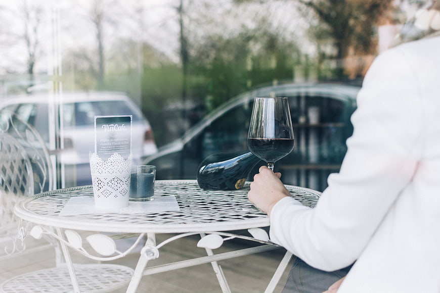 Woman drinking red wine at cafe table