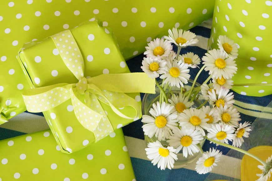 Green Polka Dot Gifts and White Daisies on Blue Striped Table