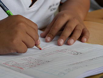 Child Writing Numbers in Notebook with Pencil