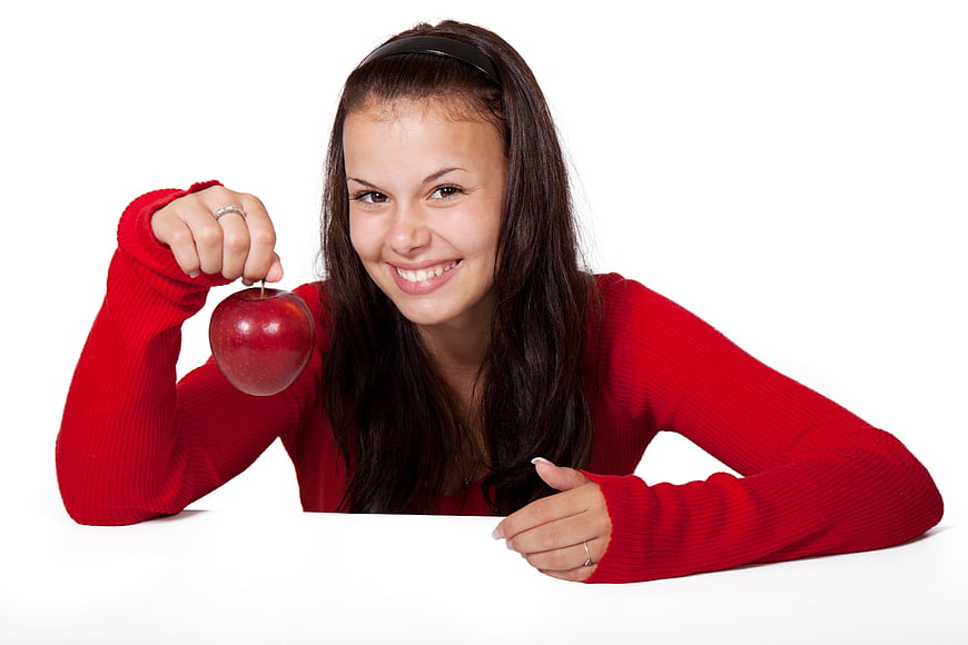 Smiling Young Woman Holding Red Apple on White Background