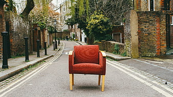 Red armchair sitting alone on a quiet residential street