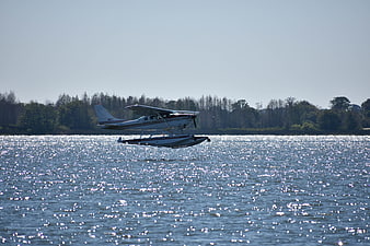 Seaplane taking off from sparkling lake water