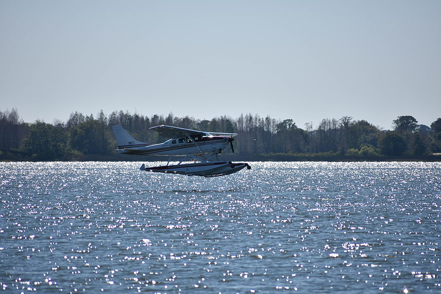 Seaplane taking off from sparkling lake water