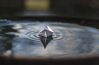 White Origami Paper Boat Floating on Water