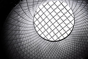 Black and white modern architecture looking up at circular glass skylight