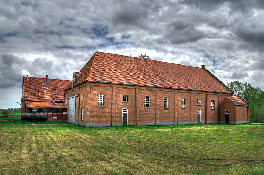 Old red brick industrial building under dramatic cloudy sky