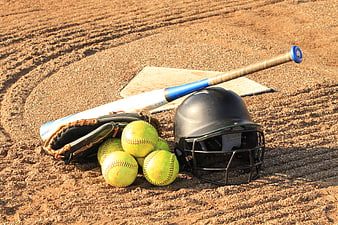 Softball equipment on dirt field with helmet and bat