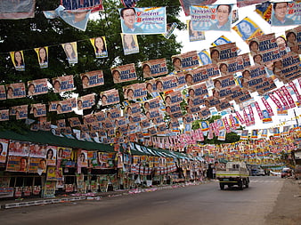 Dense Political Campaign Posters Lining a Street