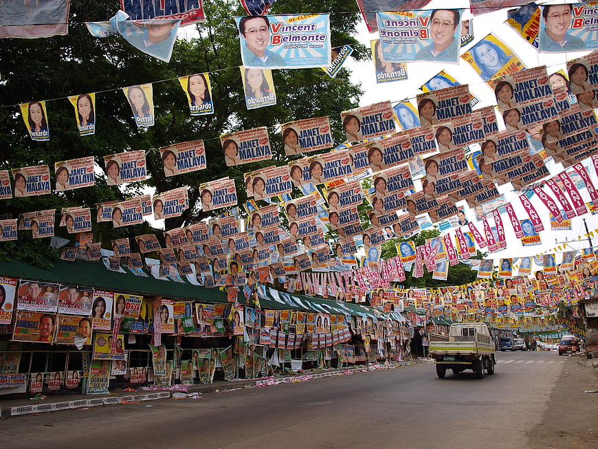 Dense Political Campaign Posters Lining a Street