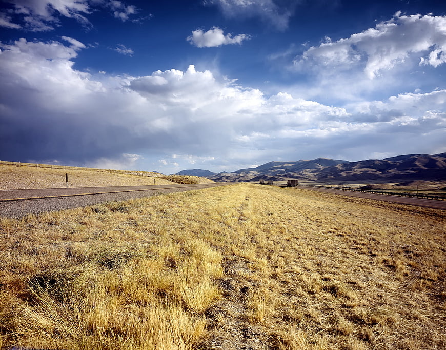 Scenic rural highway through golden fields and mountains