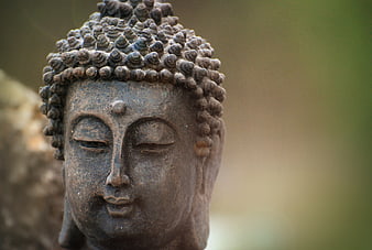 Close-up of weathered stone Buddha head statue with serene expression
