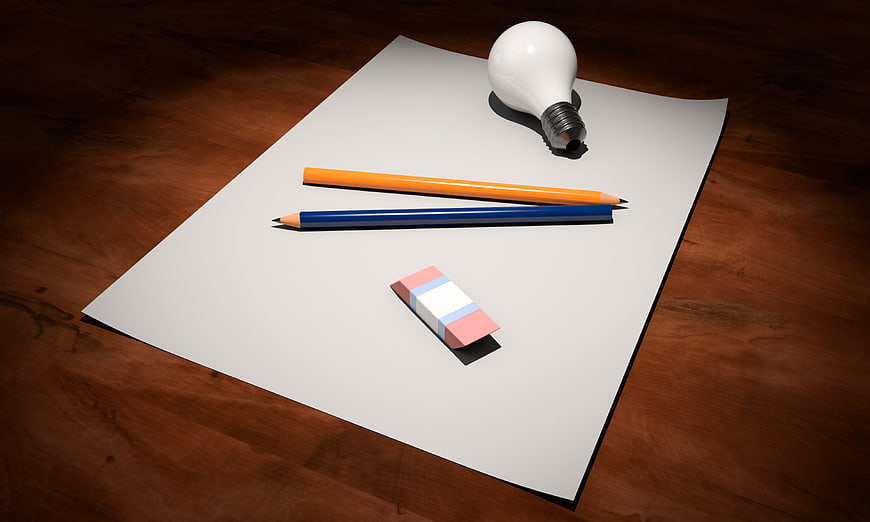 Light bulb, pencils, and eraser on blank paper for creative ideas