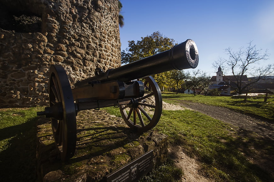 Historic cannon on stone pedestal in castle courtyard
