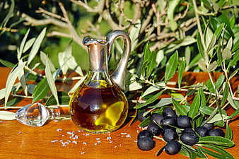 Glass Carafe of Olive Oil with Black Olives and Branches