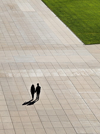 High angle view of couple walking on paved plaza