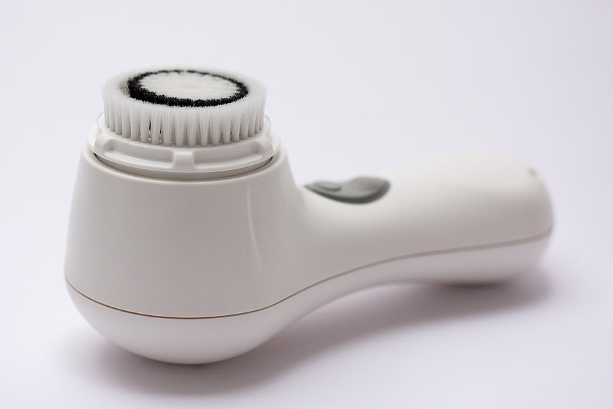 White Electric Facial Cleansing Brush With Bristle Head On White Background