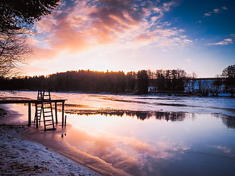 Serene Winter Sunset Over Frozen Lake with Wooden Dock