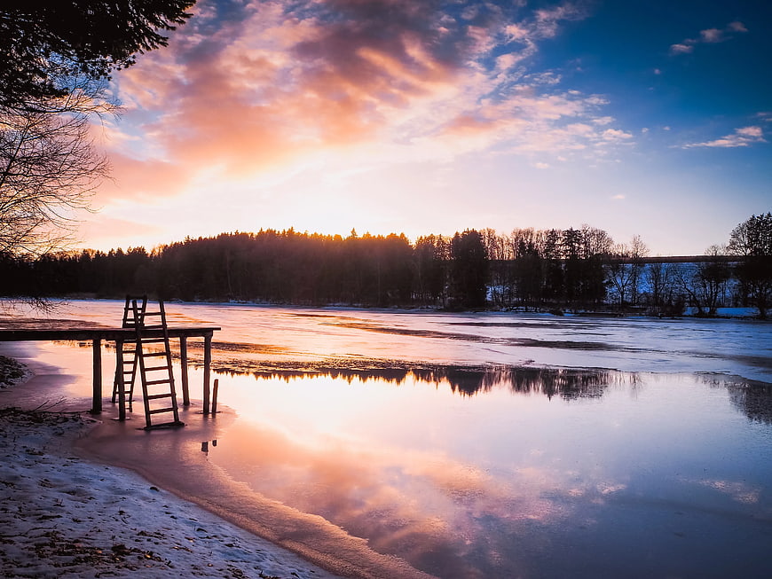 Serene Winter Sunset Over Frozen Lake with Wooden Dock