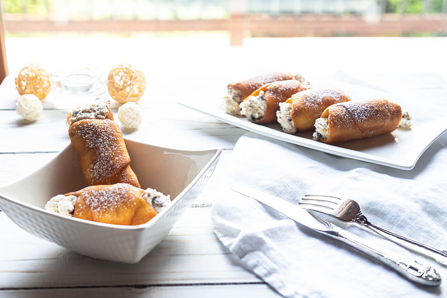 Homemade Cannoli with Ricotta Filling on White Plates