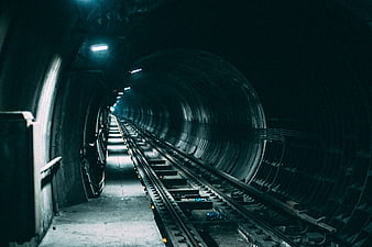 Dark subway tunnel with tracks and blue lighting