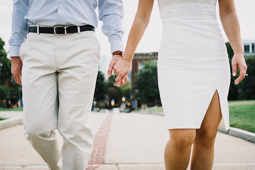 Couple holding hands walking outdoors in formal attire