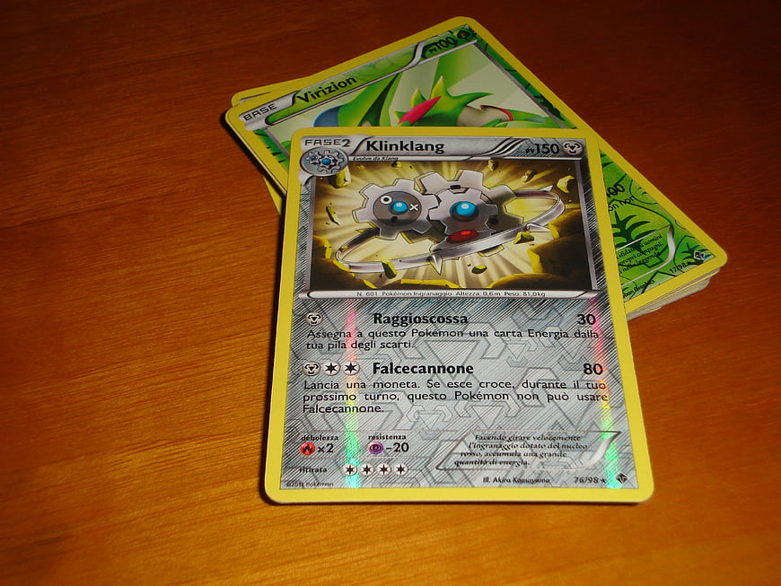 Italian Klinklang Pokemon Card on Wooden Table