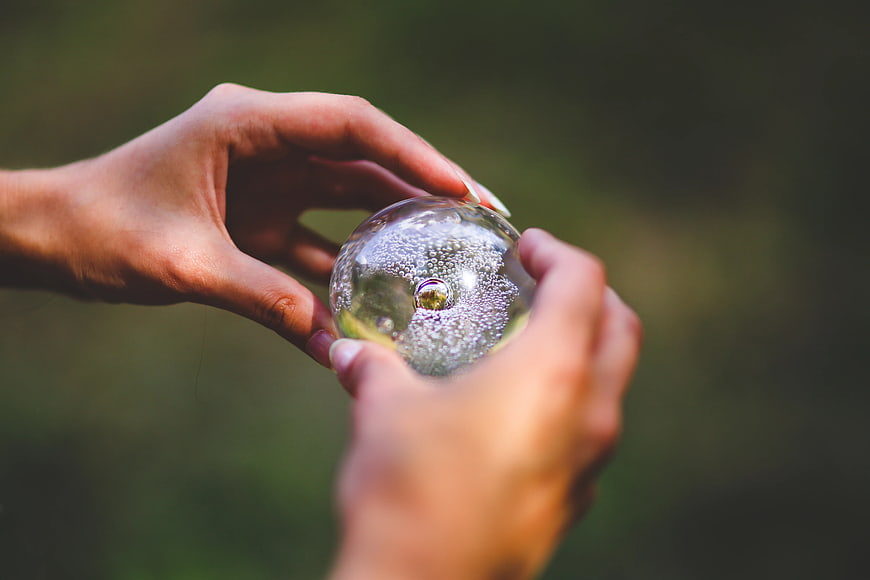 Hands holding a crystal ball with bubbles