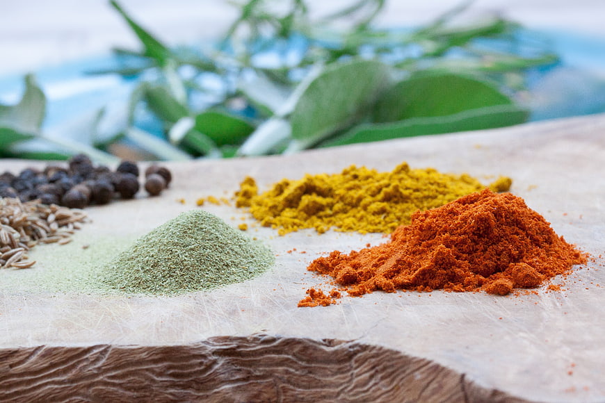 Assorted Spices and Herbs on Rustic Wooden Cutting Board