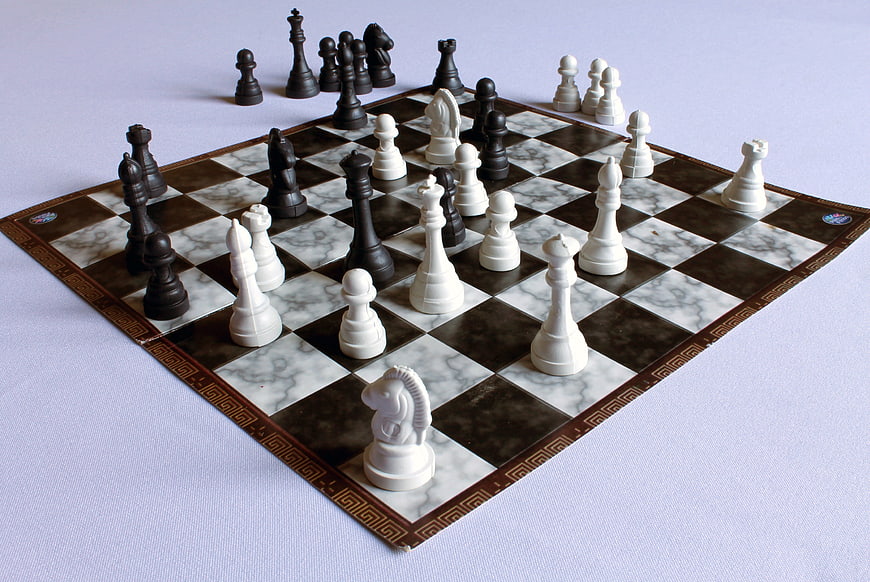 Marble Chess Board With Black And White Pieces In Mid-Game