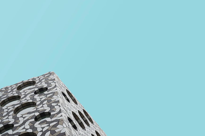 Modern geometric building facade against clear blue sky
