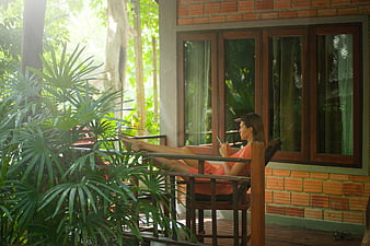 Woman relaxing on wooden porch with smartphone