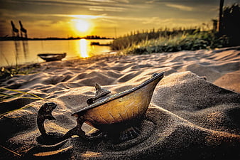Vintage brass genie lamp on sand dunes at sunset