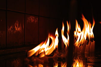 Close-up of burning prayer candles in a dark church